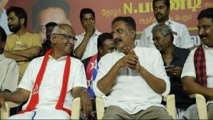 Actor Prakash Raj standing on a campaign vehicle in Palani, waving to the crowd alongside CPIM candidate Pandi.
