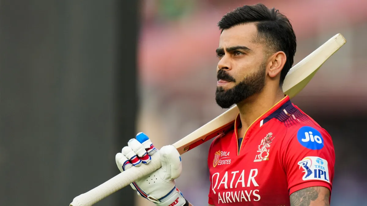 Royal Challengers Bengaluru star batter Virat Kohli raising his bat after scoring a brilliant half-century during an IPL 2026 league match.