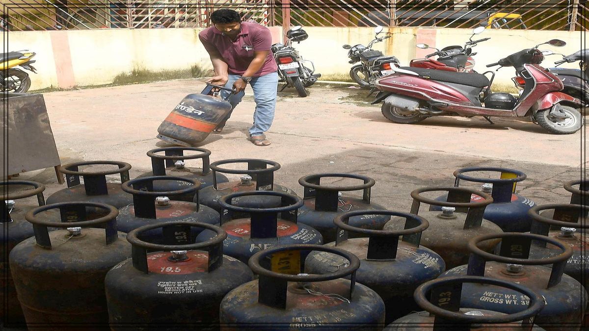 Rows of commercial blue LPG gas cylinders lined up securely at a regional petroleum distribution warehouse safety zone.