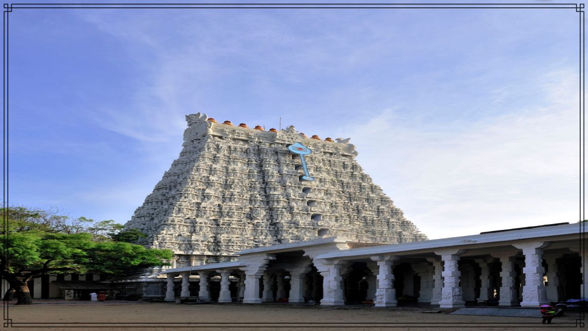Towering traditional white stone Gopuram architecture of a coastal South Indian temple structure under daylight.